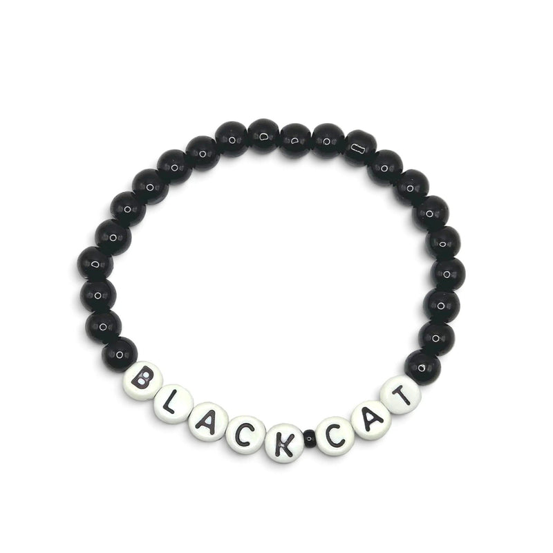A beaded bracelet composed of glossy black round beads with white letter beads spelling 'BLACKCAT' on a plain light background.