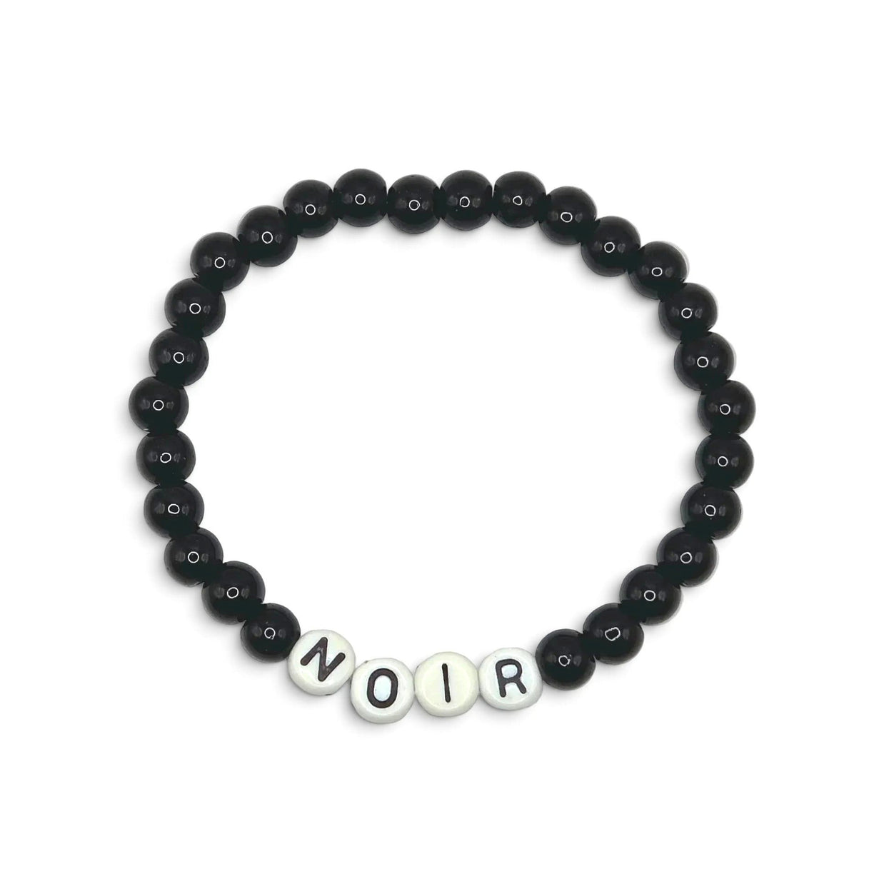 A beaded stretch bracelet featuring matte black round beads and four white letter beads spelling 'NOIR' at the bottom, displayed on a clean white background.