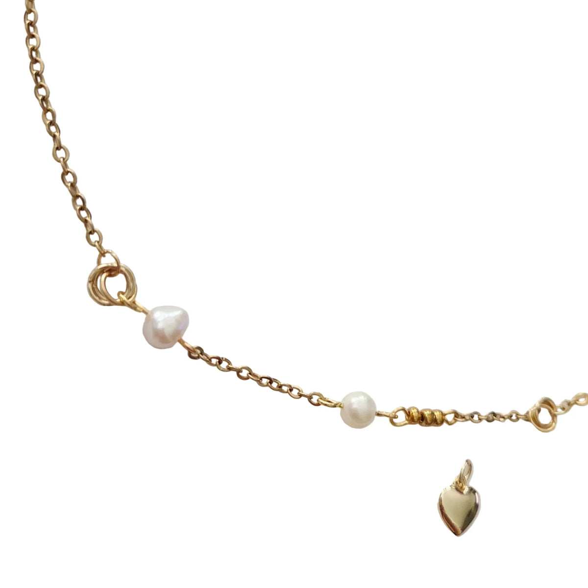 A delicate gold chain necklace featuring small white baroque pearls, a gold heart charm, and a gold ring clasp, displayed on a light gray background.