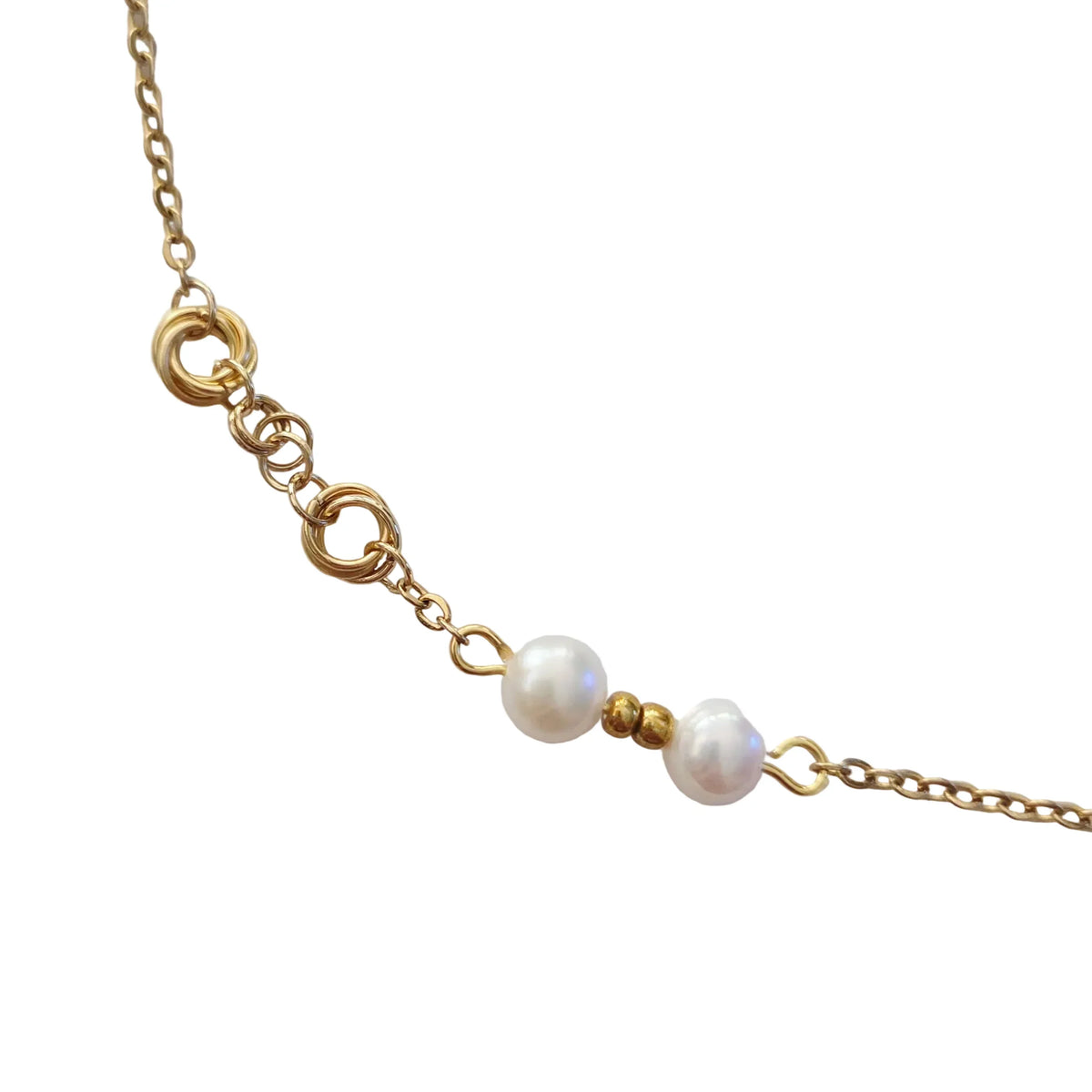 A close-up of a gold chain bracelet featuring two white freshwater pearls and small gold spacer beads, displayed on a clean white background.