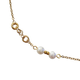 A close-up of a gold chain bracelet featuring two white freshwater pearls and small gold spacer beads, displayed on a clean white background.