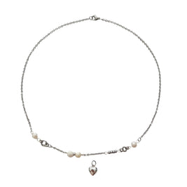 A delicate silver chain necklace featuring small white pearl beads and a dangling silver heart charm, displayed on a clean white background.
