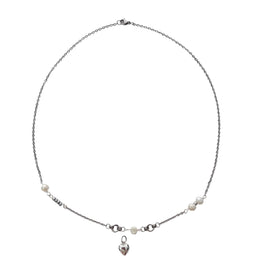 A delicate silver chain necklace featuring small white pearl beads and a small dangling heart charm, displayed on a plain white surface.