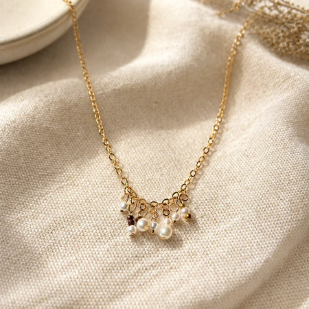 Delicate gold chain necklace with pearl and bead charms, handmade for everyday elegance and cozy gifting.