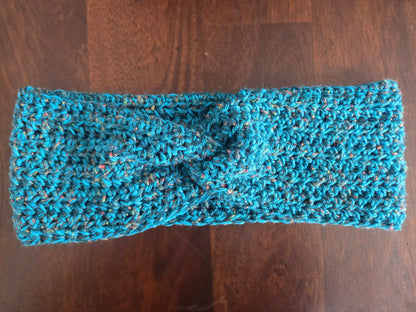 Handmade blue crochet headband with twist knot on wooden table