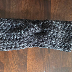 Handmade chunky knit charcoal headband on dark wooden table