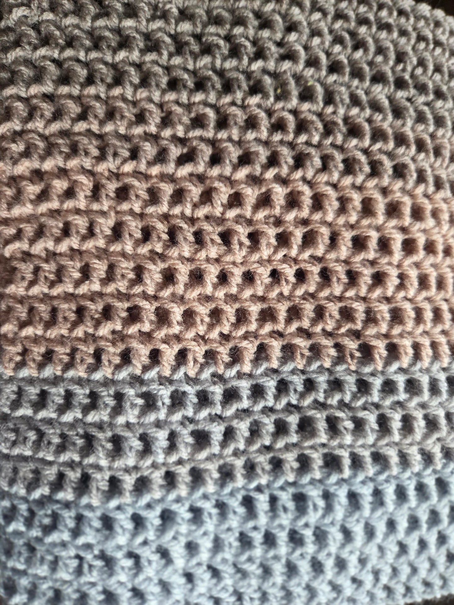 Close-up of crochet fabric with beige and blue yarn texture