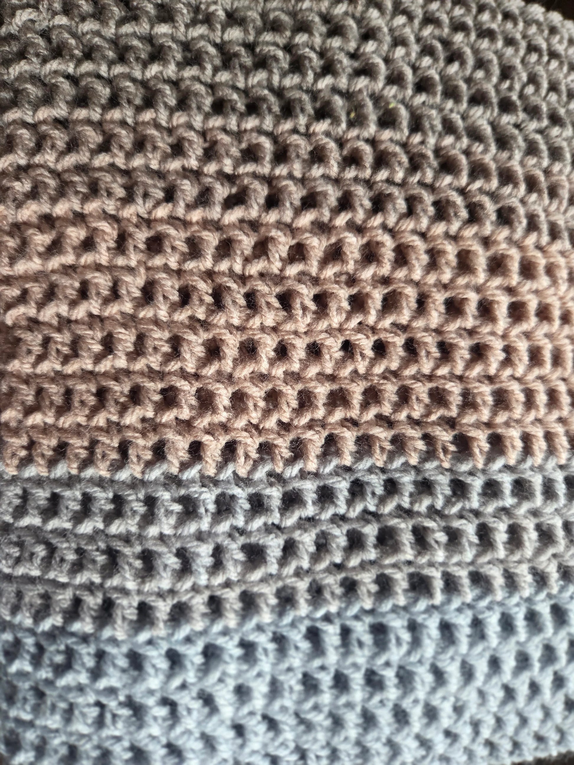 Close-up of crochet fabric with beige and blue yarn texture