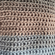 Close-up of crochet fabric with beige and blue yarn texture