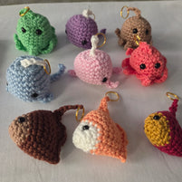 Colorful crochet sea creature keychains arranged on a white surface