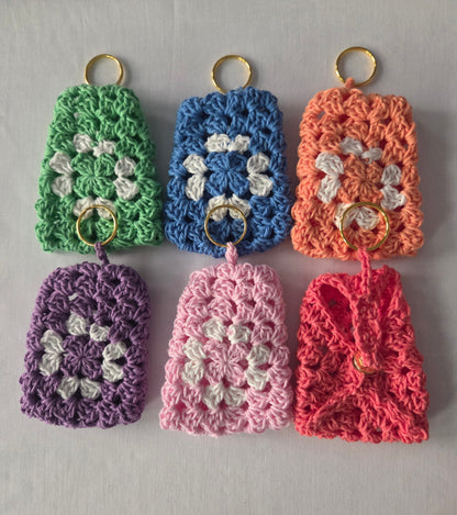 Colorful crochet keychain covers with granny square design on a light background