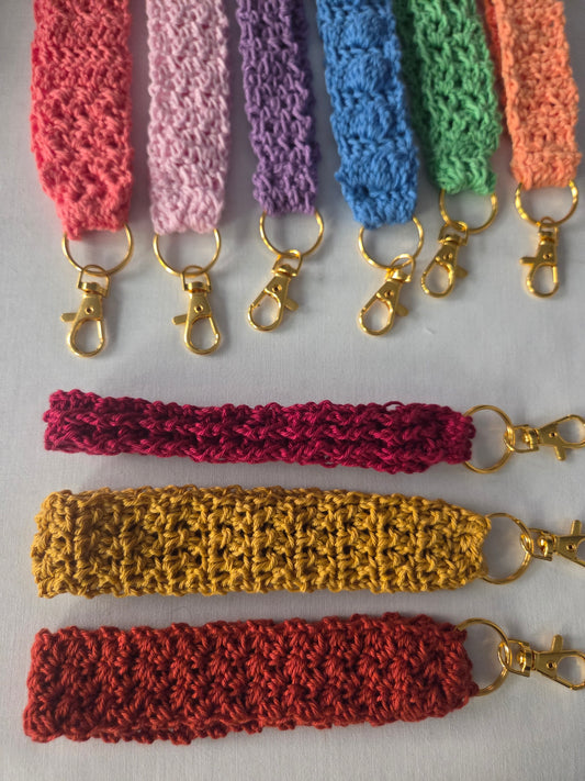 Colorful crochet keychains with gold clasps displayed on a white background