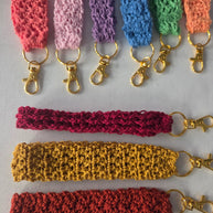 Colorful crochet keychains with gold clasps displayed on a white background