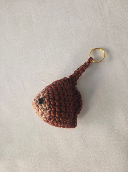 Handmade crochet stingray keychain in brown yarn on a white background