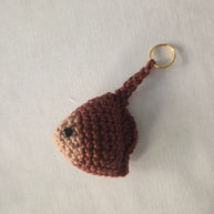 Handmade crochet stingray keychain in brown yarn on a white background