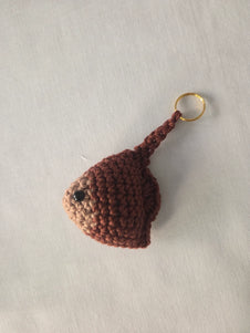 Handmade crochet stingray keychain in brown yarn on a white background
