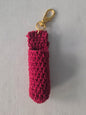 Handmade red crochet keychain pouch with gold clasp on light fabric background