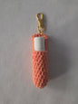 Peach crochet lip balm holder keychain with white tube and gold clasp on white background