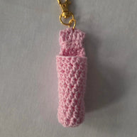 Pink crochet keychain holder with gold clasp on light background