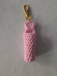 Pink crochet keychain holder with gold clasp on light background