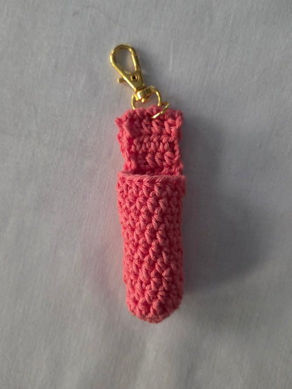 Handmade pink crochet keychain pouch with gold clasp on a light background