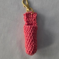 Handmade pink crochet keychain pouch with gold clasp on a light background
