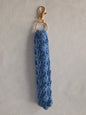 Handmade blue crochet keychain with gold clasp on a light background