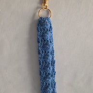 Handmade blue crochet keychain with gold clasp on a light background