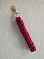 Handmade maroon crochet keychain with gold clasp on light background