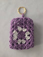 Purple and white crochet granny square keychain with gold ring on white background