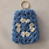 Blue and white crochet granny square keychain on a light background