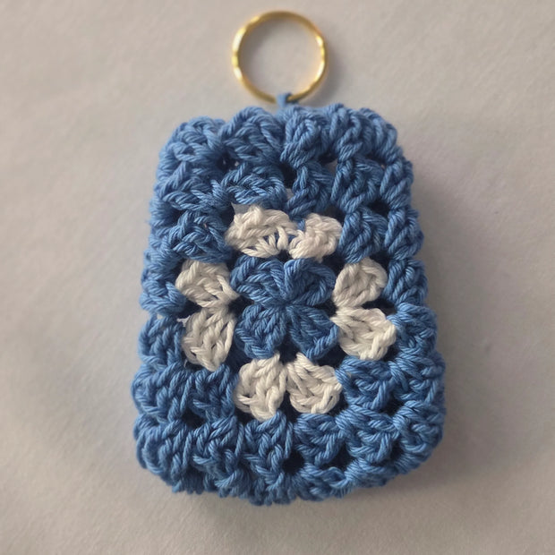 Blue and white crochet granny square keychain on a light background