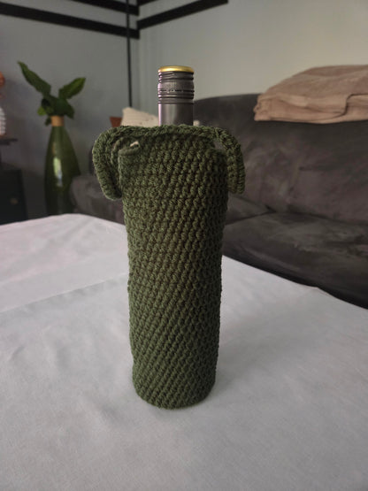 Green crochet wine bottle cover on table with grey couch in background