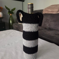 Wine bottle in black and white striped crochet cover on table in modern living room