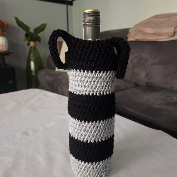 Wine bottle in black and white striped crochet cover on table in modern living room