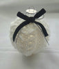White knitted Christmas ornament with black velvet bow on plain background
