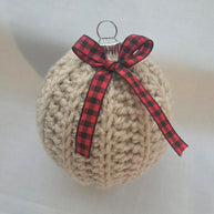 Crocheted Christmas ornament with red plaid bow on white background