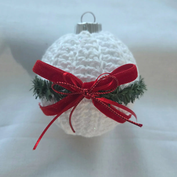 White crochet Christmas ornament with pine garnish and red velvet ribbon bow
