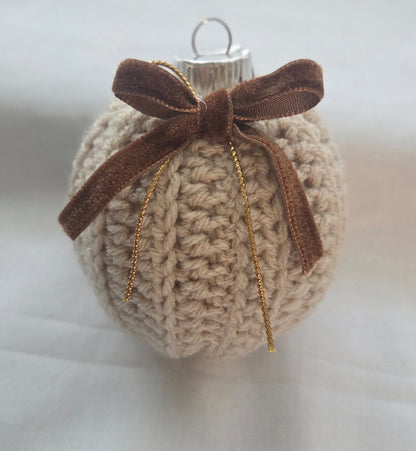 Crocheted Christmas ornament with brown velvet bow on white background