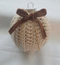 Crocheted Christmas ornament with brown velvet bow on white background