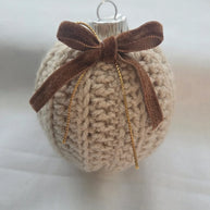 Crocheted Christmas ornament with brown velvet bow on white background