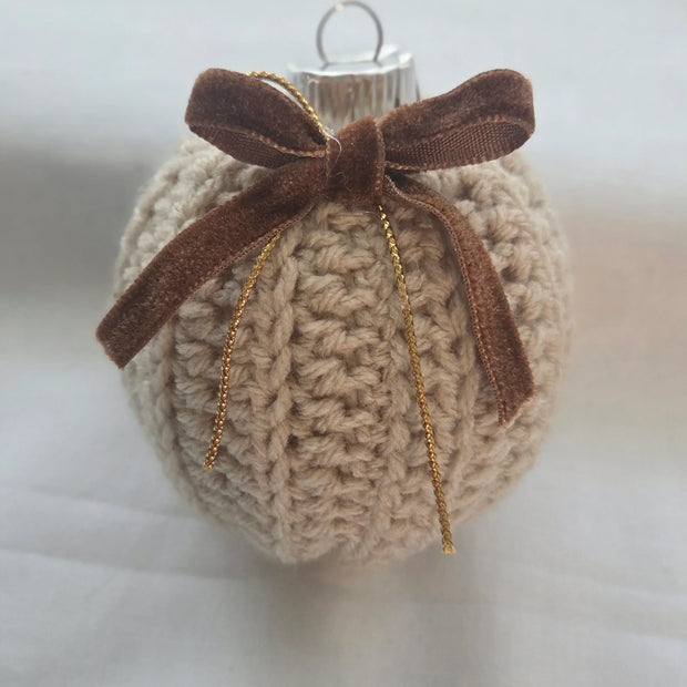 Crocheted Christmas ornament with brown velvet bow on white background