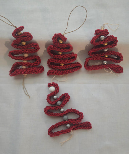 Handmade red crochet Christmas tree ornaments with beads on white background