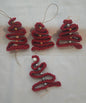 Handmade red crochet Christmas tree ornaments with beads on white background
