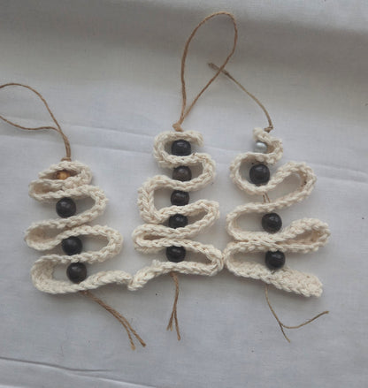 Handmade macrame Christmas tree ornament with black beads on white fabric