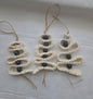 Handmade macrame Christmas tree ornament with black beads on white fabric