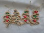 Handmade crochet Christmas tree ornaments with red, green, and blue wooden beads on white background