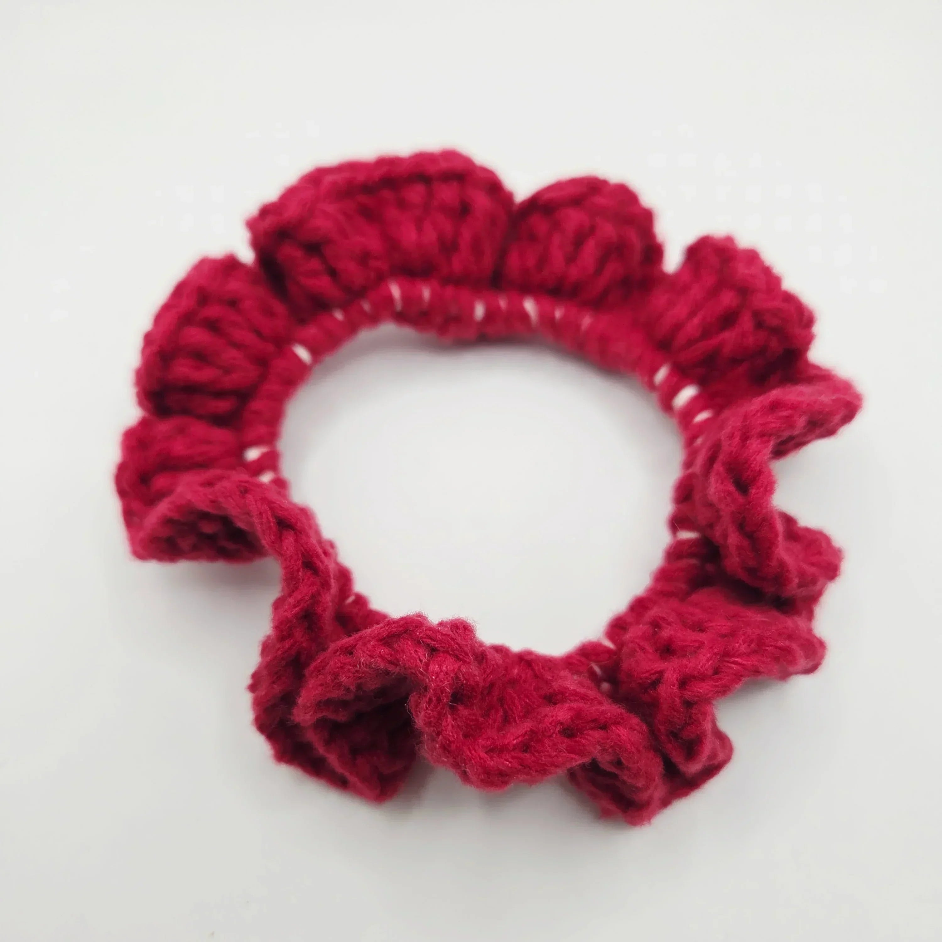 Handmade red crochet hair scrunchie with ruffled texture, cozy and creative accessory