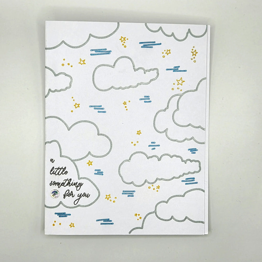 Handmade greeting card with silver clouds, gold stars, blue rain, and 'a little something for you' text