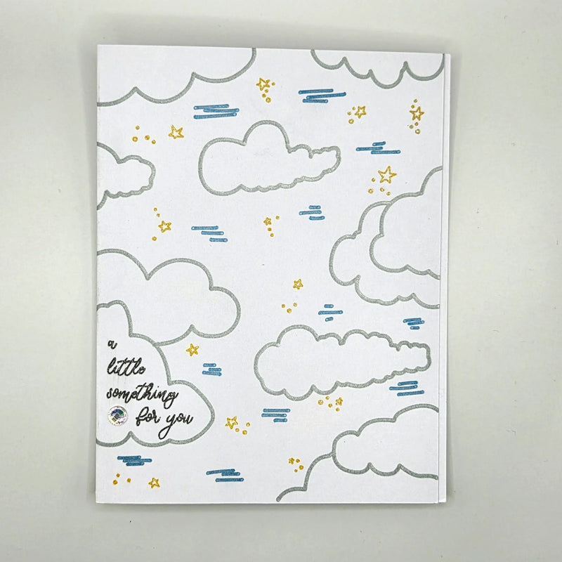 Handmade greeting card with silver clouds, gold stars, blue rain, and 'a little something for you' text